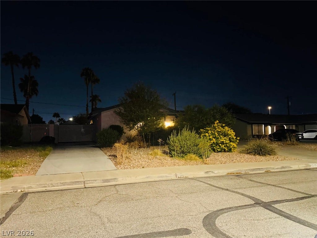 Lush desert landscaping and a paved driveway enhance the streetscape of this residential property.