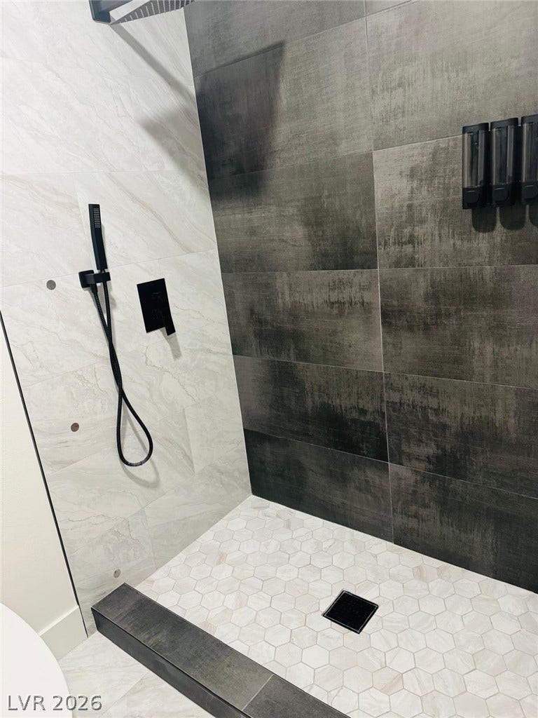 Contrasting tiles and modern fixtures create a sleek, contemporary walk-in shower experience.