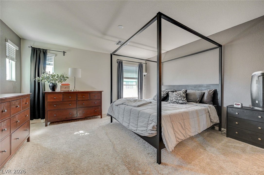 Soft carpet and natural light from multiple windows define this peaceful sleeping space.