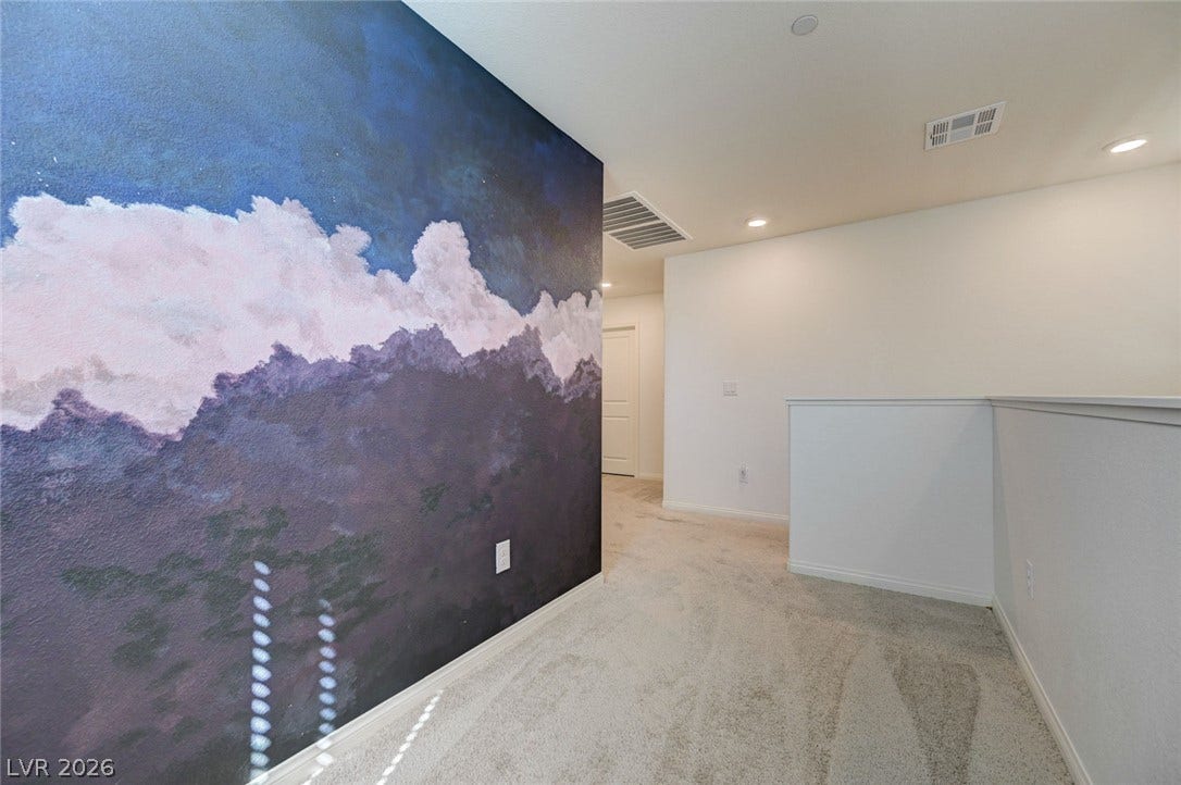 A spacious upper-level landing features soft wall-to-wall carpeting and recessed lighting.