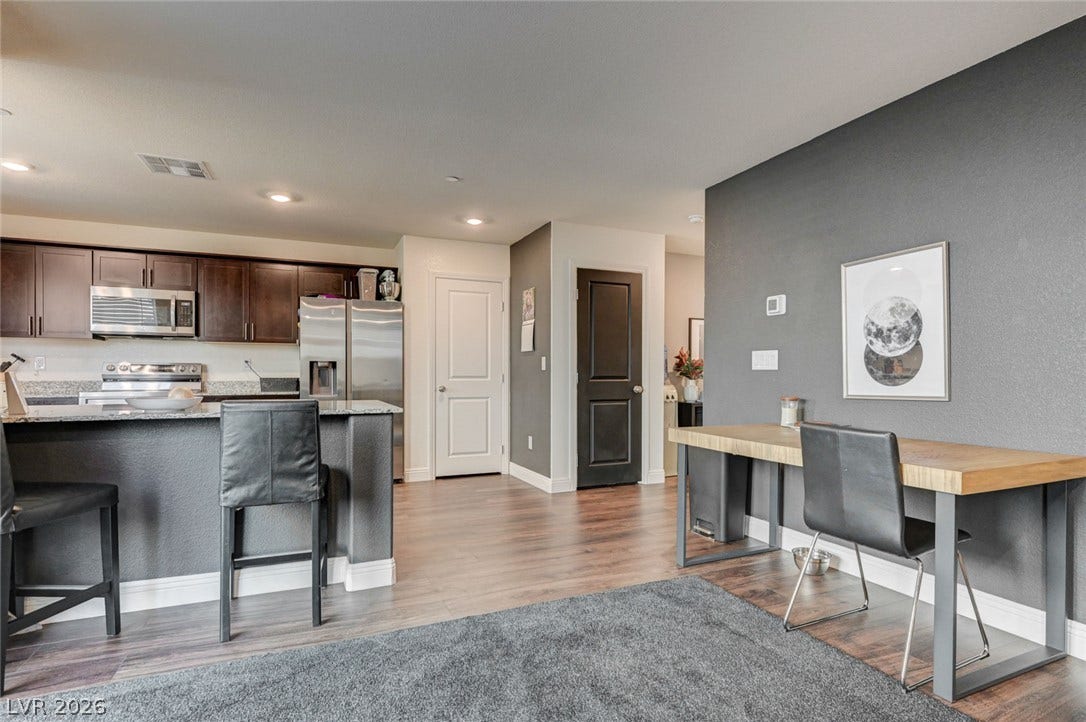 Gleaming hardwood floors and recessed lighting enhance the open layout near the kitchen.