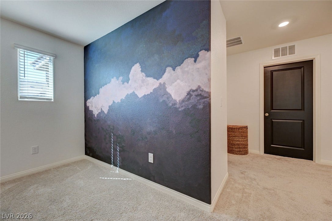 Soft carpeting pairs with recessed lighting to create a comfortable and inviting atmosphere.