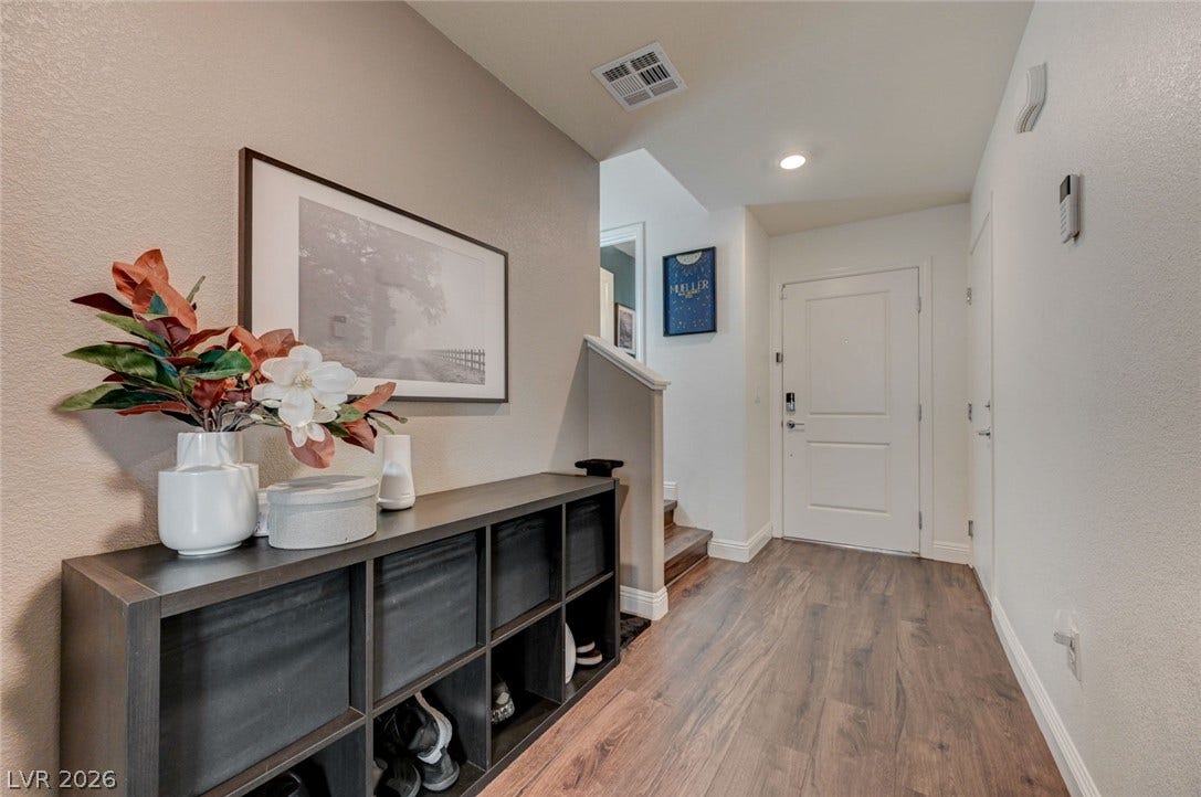 Smooth wood-plank flooring guides visitors into a welcoming entryway featuring clean modern lines.