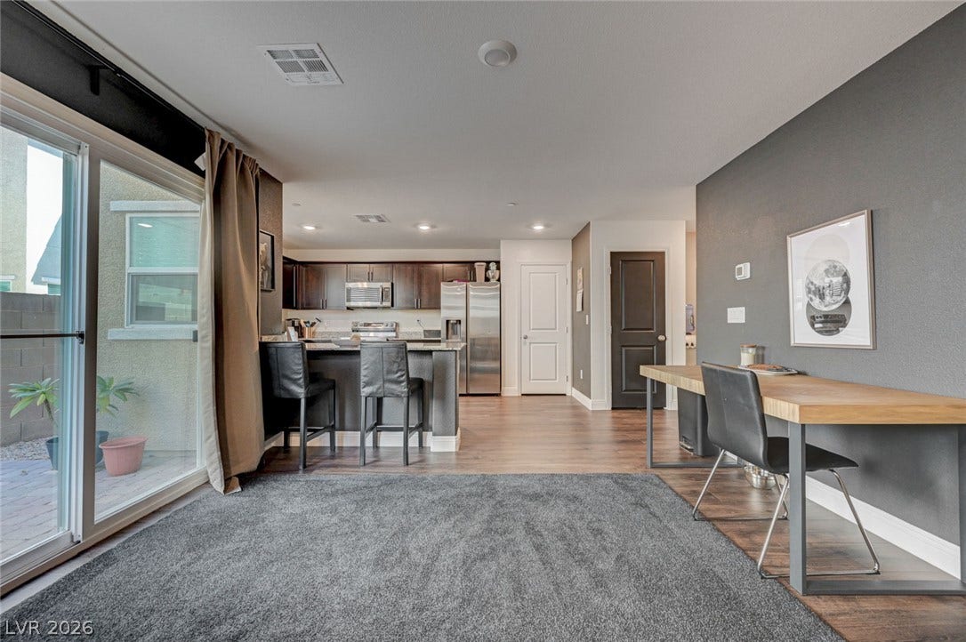 An open floorplan seamlessly connects the versatile living area to a modern kitchen.