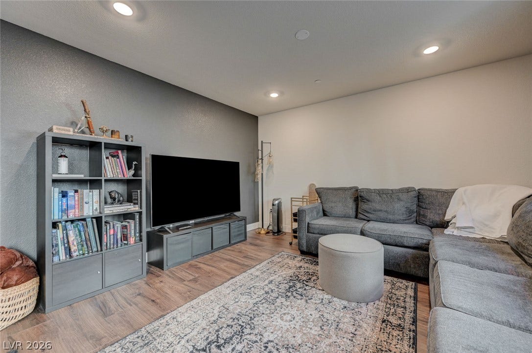Smooth wood-style flooring and modern recessed lighting create a comfortable living space.