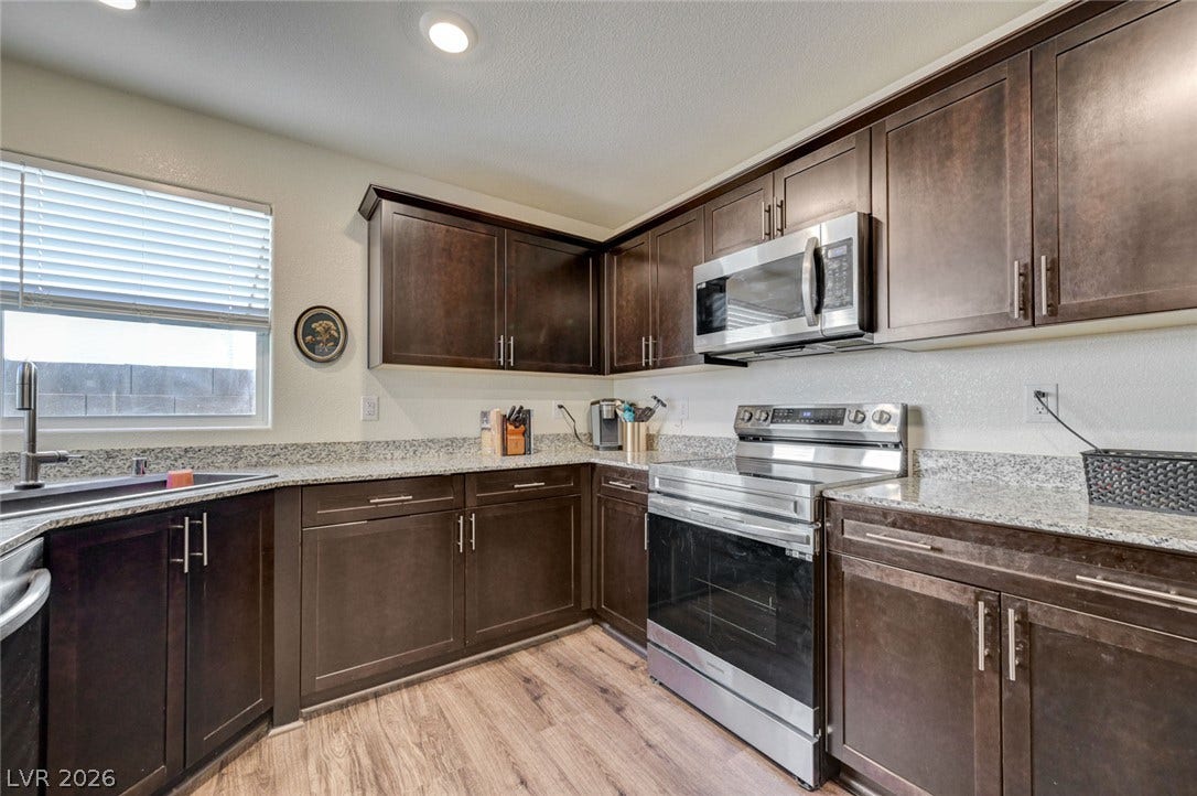 Rich wood cabinetry and granite countertops frame this efficient workspace.