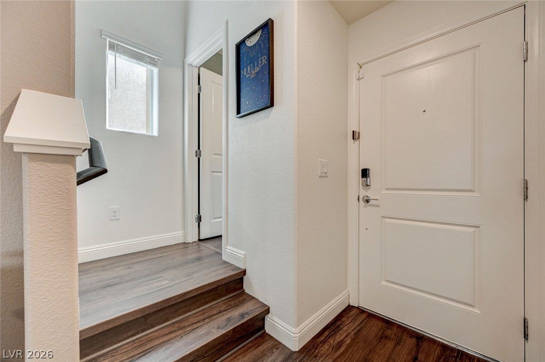 An inviting entryway transitions smoothly via wood-toned steps toward the upper living areas.