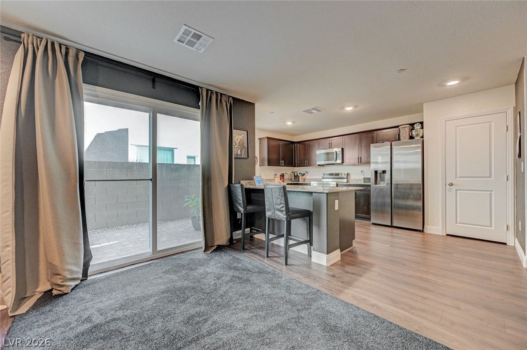 Sliding glass doors open from the hard-surface dining area to a private paved patio.