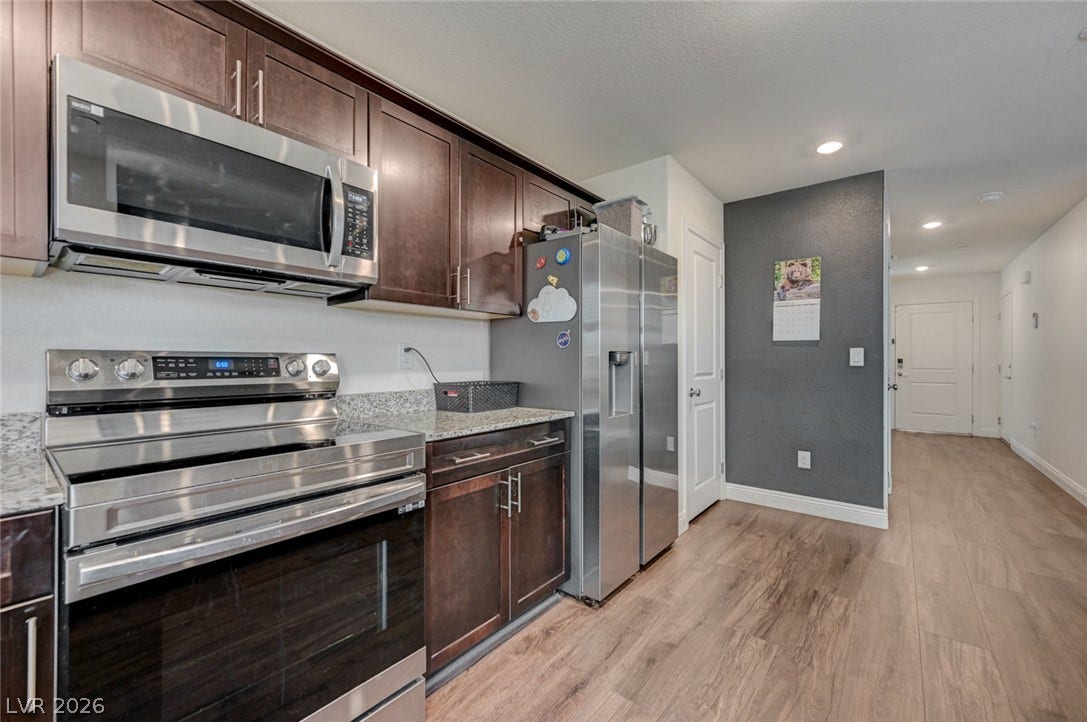 Rich wood cabinetry and stone countertops accent this modern culinary space.
