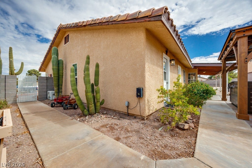 251 W Laval Drive, Henderson, NV 89015 Concrete walkways connect the home's outdoor spaces while mature desert landscaping adds character and low-maintenance appeal.