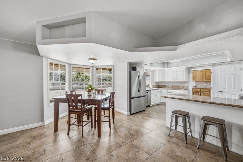 251 W Laval Drive, Henderson, NV 89015 Bright dining area surrounded by windows flows seamlessly into the kitchen, creating an inviting space for casual meals, morning coffee, and entertaining.