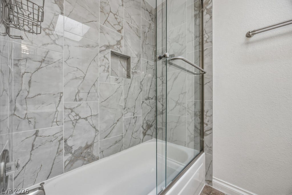 251 W Laval Drive, Henderson, NV 89015 Eye-catching tile extends throughout the tub and shower surround, complemented by a glass enclosure and convenient built-in shower niche.