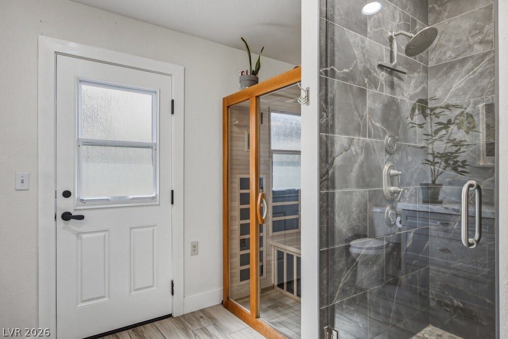 251 W Laval Drive, Henderson, NV 89015 Beautifully finished walk-in shower features dramatic floor-to-ceiling tile, a pebble-accent niche, built-in bench, handheld shower head, and multiple body sprays.