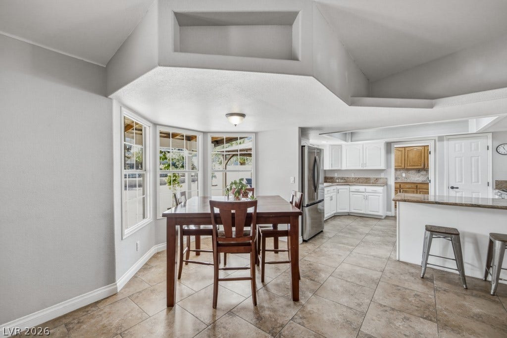 251 W Laval Drive, Henderson, NV 89015 Bright dining area surrounded by windows flows seamlessly into the kitchen, creating an inviting space for casual meals, morning coffee, and entertaining.