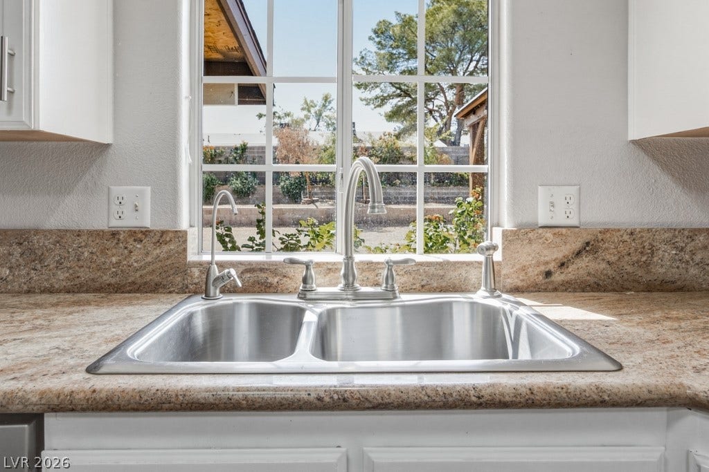 251 W Laval Drive, Henderson, NV 89015 Even everyday tasks come with a view! A large window above the double-basin sink fills the kitchen with natural light while overlooking the backyard.