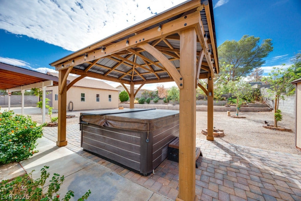 251 W Laval Drive, Henderson, NV 89015 The spa sits beneath its own pergola on a paver patio, creating a dedicated outdoor relaxation space.