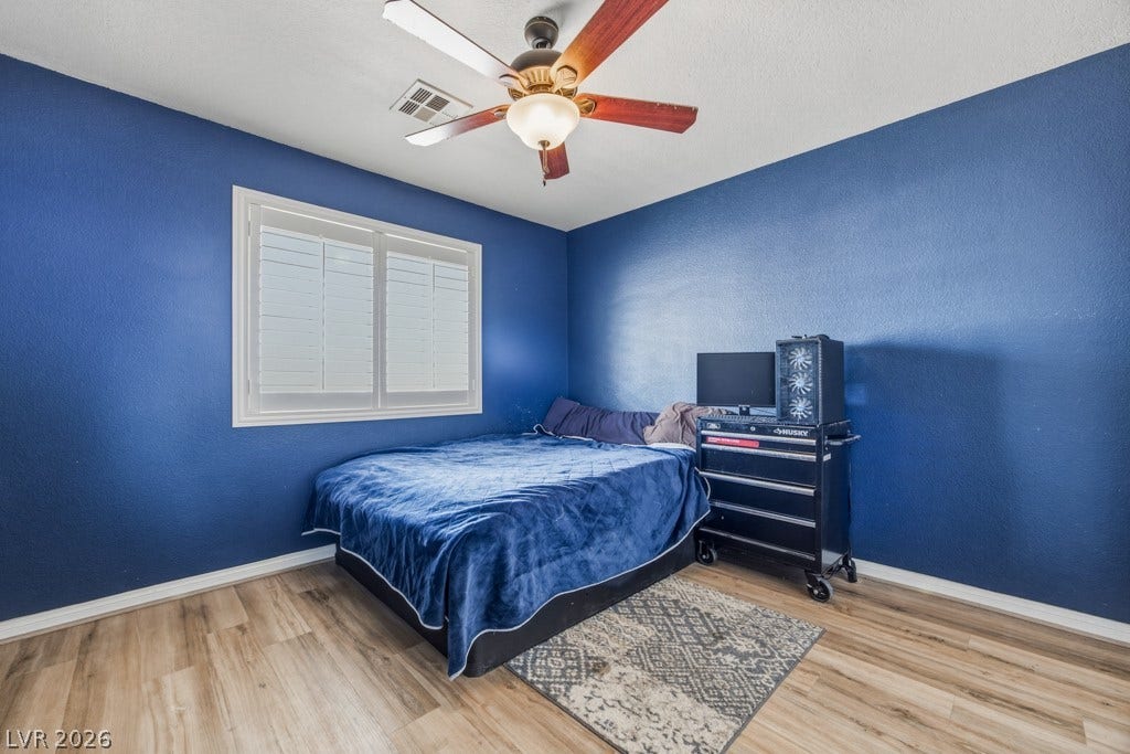 251 W Laval Drive, Henderson, NV 89015 Comfortable secondary bedroom features wood-look flooring, plantation shutters, plenty of natural light, a ceiling fan, and easy access to the guest bathroom.