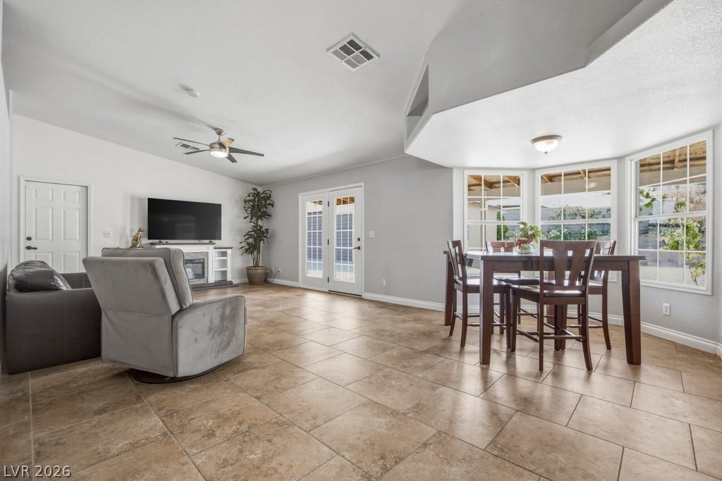 251 W Laval Drive, Henderson, NV 89015 Spacious and open family and dining area features tile flooring, vaulted architectural details, abundant natural light, and French doors leading to the covered outdoor living space.