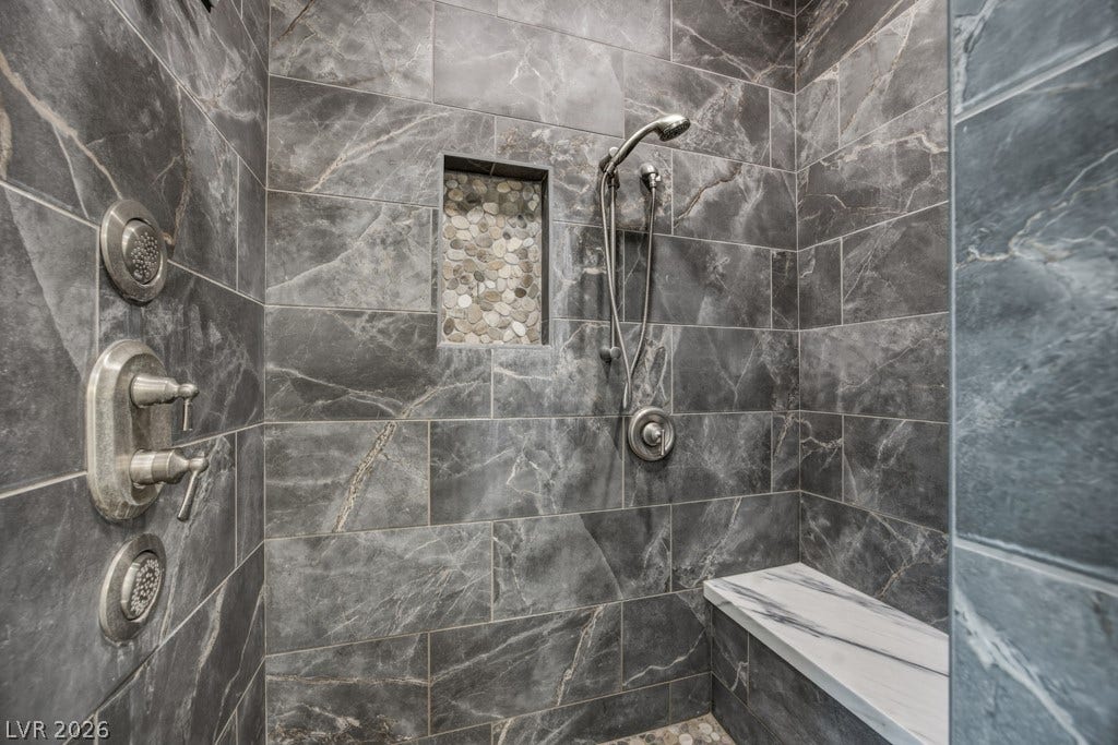 251 W Laval Drive, Henderson, NV 89015 Beautifully finished walk-in shower features dramatic floor-to-ceiling tile, a pebble-accent niche, built-in bench, handheld shower head, and multiple body sprays.
