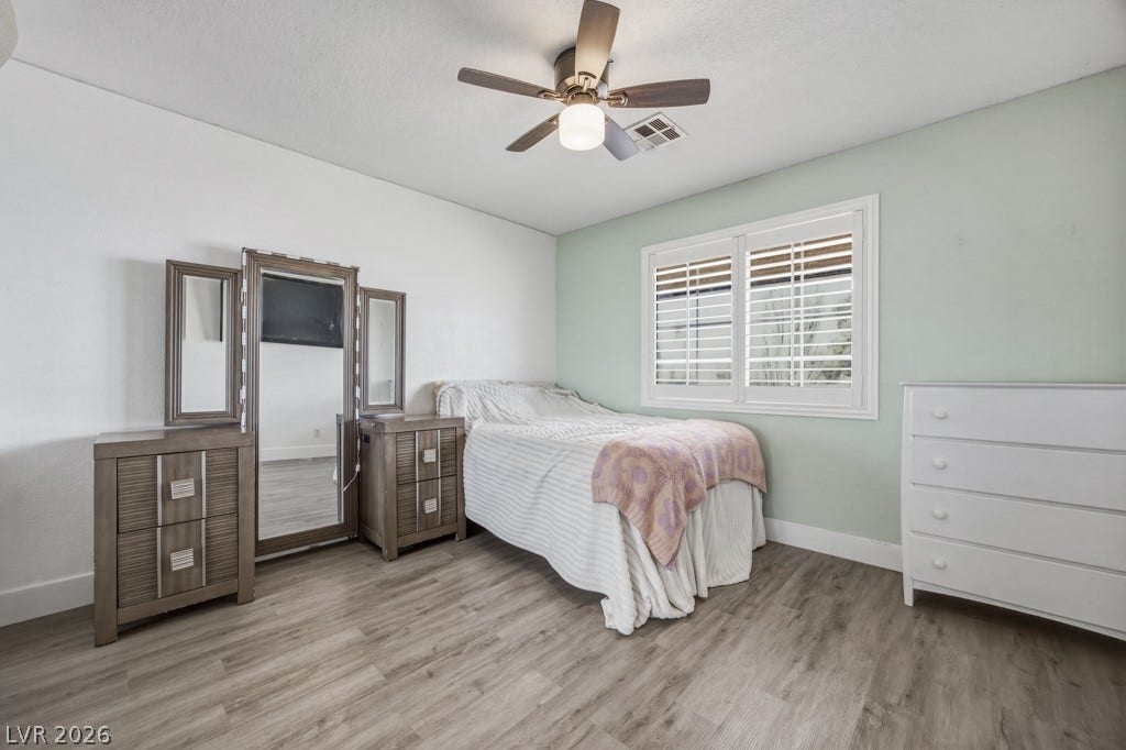 251 W Laval Drive, Henderson, NV 89015 Comfortable secondary bedroom features wood-look flooring, plantation shutters, plenty of natural light, a ceiling fan, and easy access to the guest bathroom.