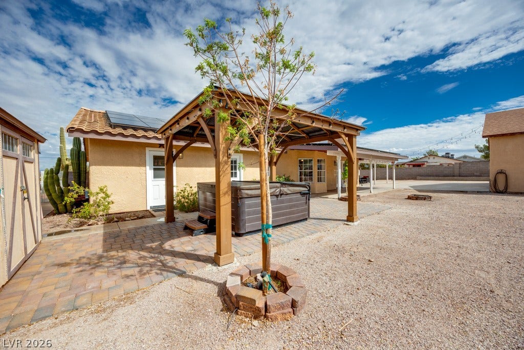 251 W Laval Drive, Henderson, NV 89015 The spa sits beneath its own pergola on a paver patio, creating a dedicated outdoor relaxation space.