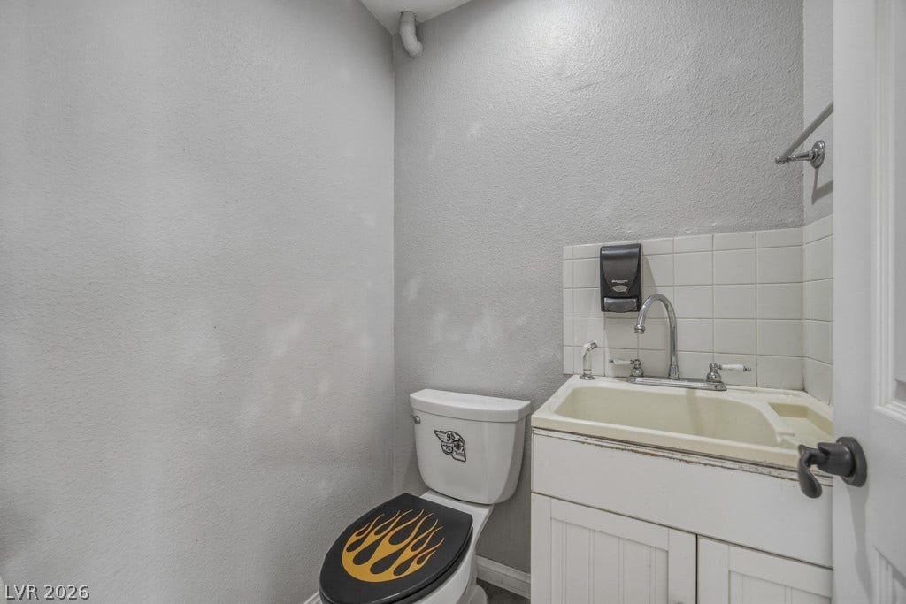 251 W Laval Drive, Henderson, NV 89015 Convenient half-bath located within the garage, featuring a vanity, toilet, and tiled flooring. A practical addition for the garage and outdoor entertaining area.