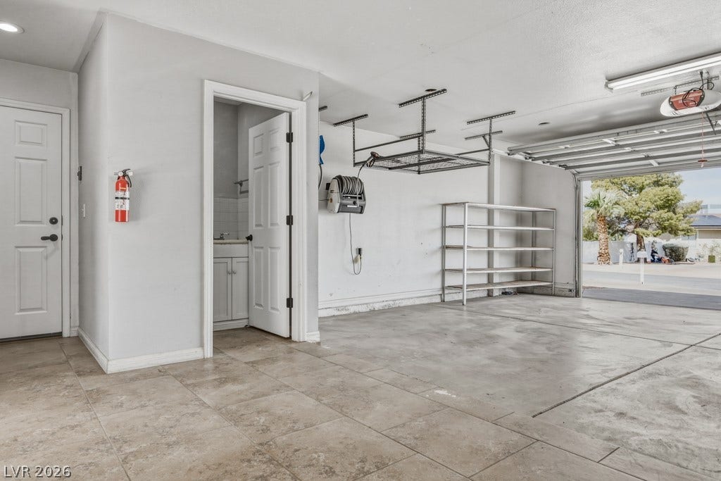 251 W Laval Drive, Henderson, NV 89015 Convenient half-bath located within the garage, featuring a vanity, toilet, and tiled flooring. A practical addition for the garage and outdoor entertaining area.