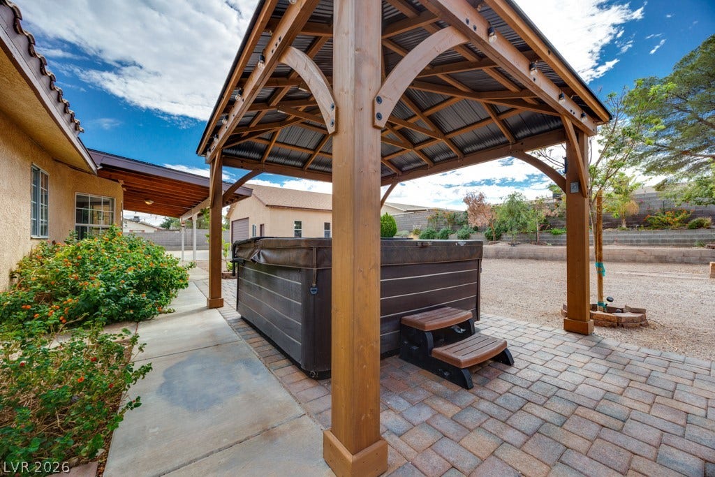 251 W Laval Drive, Henderson, NV 89015 The spa sits beneath its own pergola on a paver patio, creating a dedicated outdoor relaxation space.