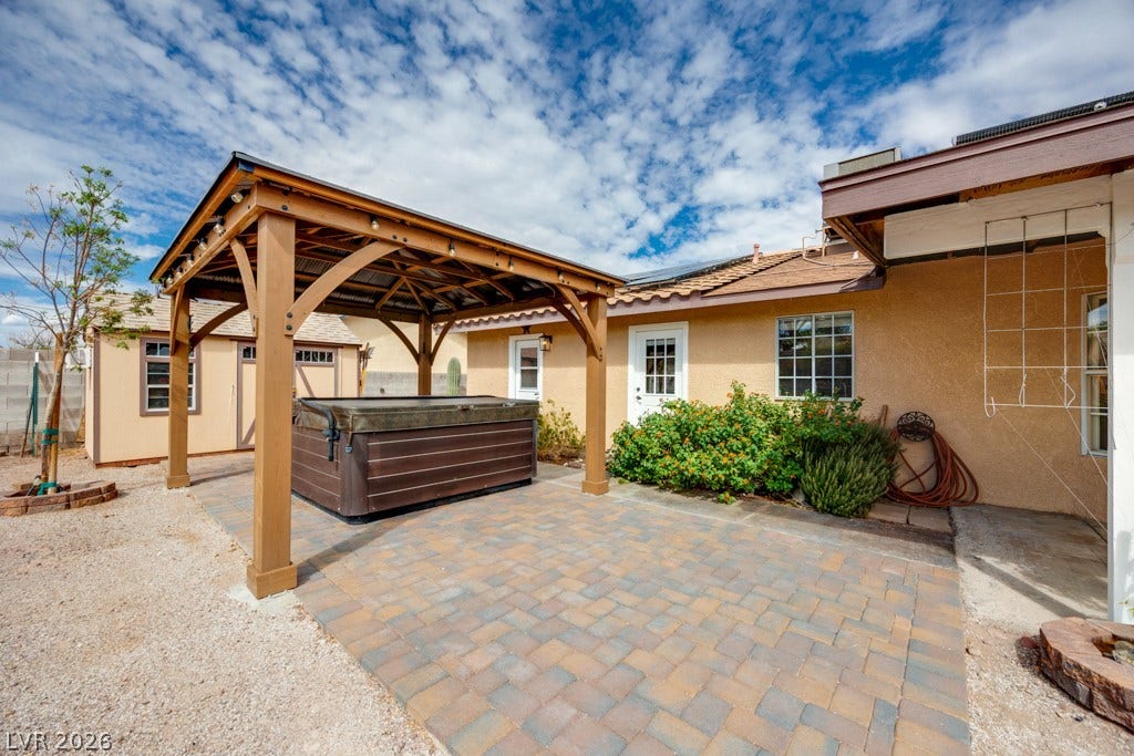 251 W Laval Drive, Henderson, NV 89015 The spa sits beneath its own pergola on a paver patio, creating a dedicated outdoor relaxation space.