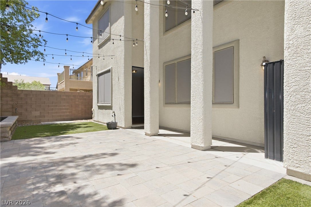 Back Yard covered patio with pavers, doors to living room and Primary Suite