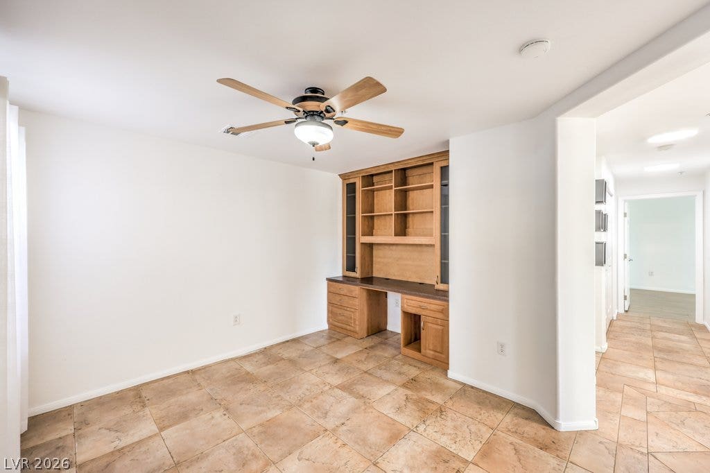 3910 Legend Hills Street, #103, Las Vegas, NV 89129 Tiled flooring and a built-in wooden desk with shelving complete this functional workspace.