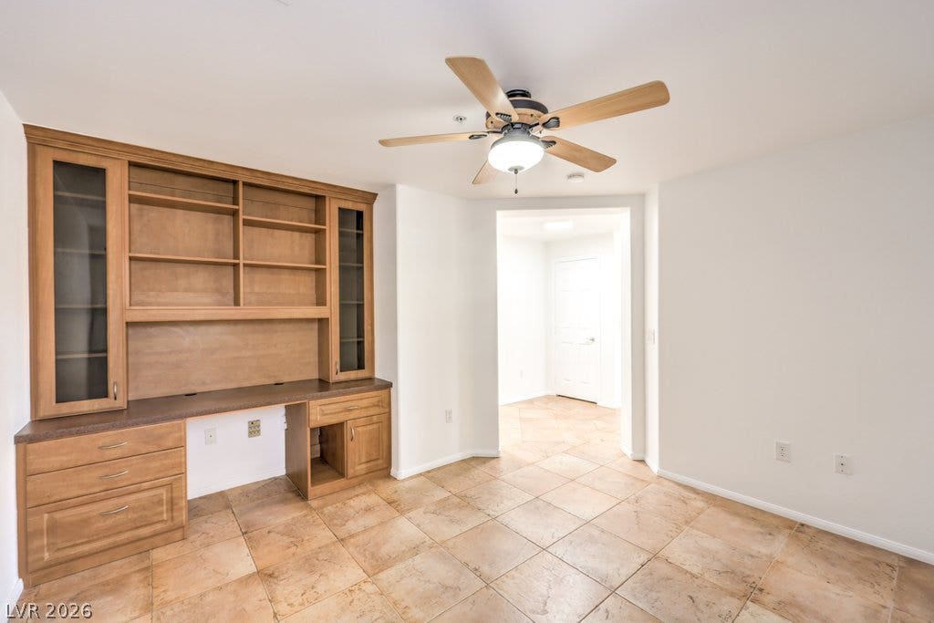 3910 Legend Hills Street, #103, Las Vegas, NV 89129 Tiled flooring runs throughout this versatile workspace featuring integrated wooden shelving and desk storage.