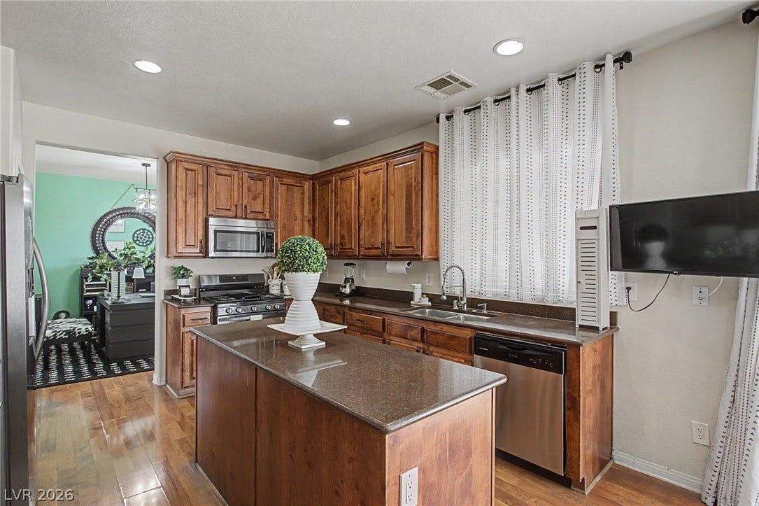 6025 Glenborough Street, North Las Vegas, NV 89115 Rich wood cabinetry paired with gleaming countertops and handsome wood floors defines the kitchen.