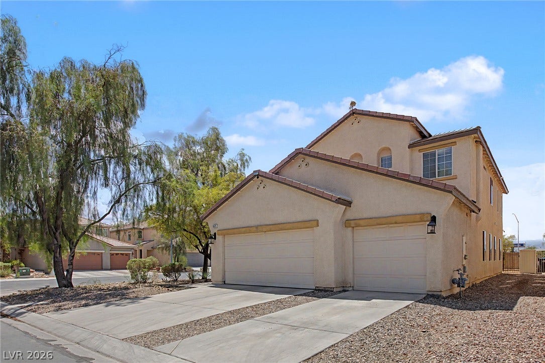 6025 Glenborough Street, North Las Vegas, NV 89115 Multi-level stucco exterior pairs classic tile roofing with functional driveway space.
