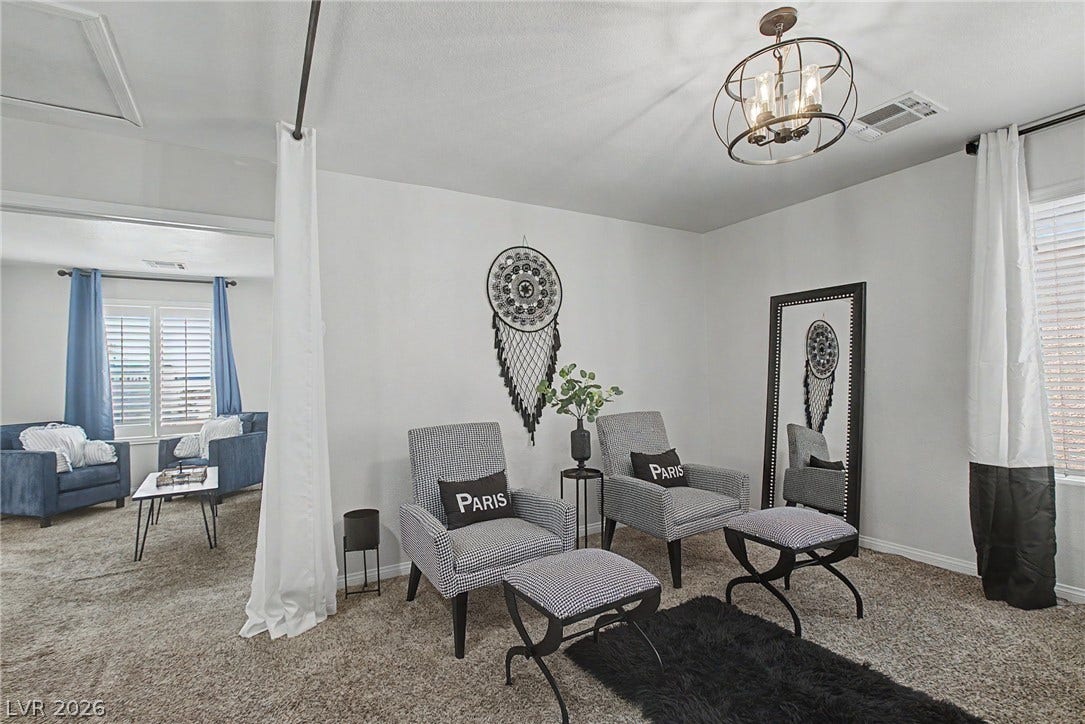 6025 Glenborough Street, North Las Vegas, NV 89115 Plush carpeting and an open archway define this versatile secondary living or dressing space.
