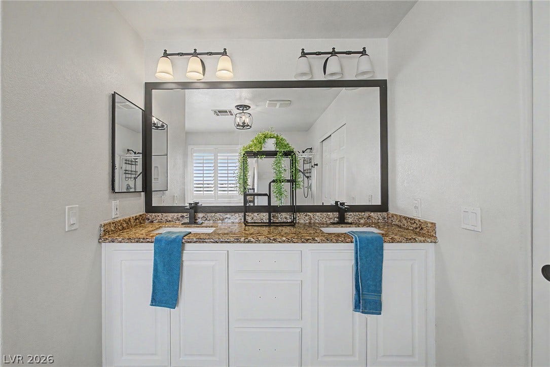 6025 Glenborough Street, North Las Vegas, NV 89115 Granite counters and a wide dual vanity enhance this well-appointed bathroom.