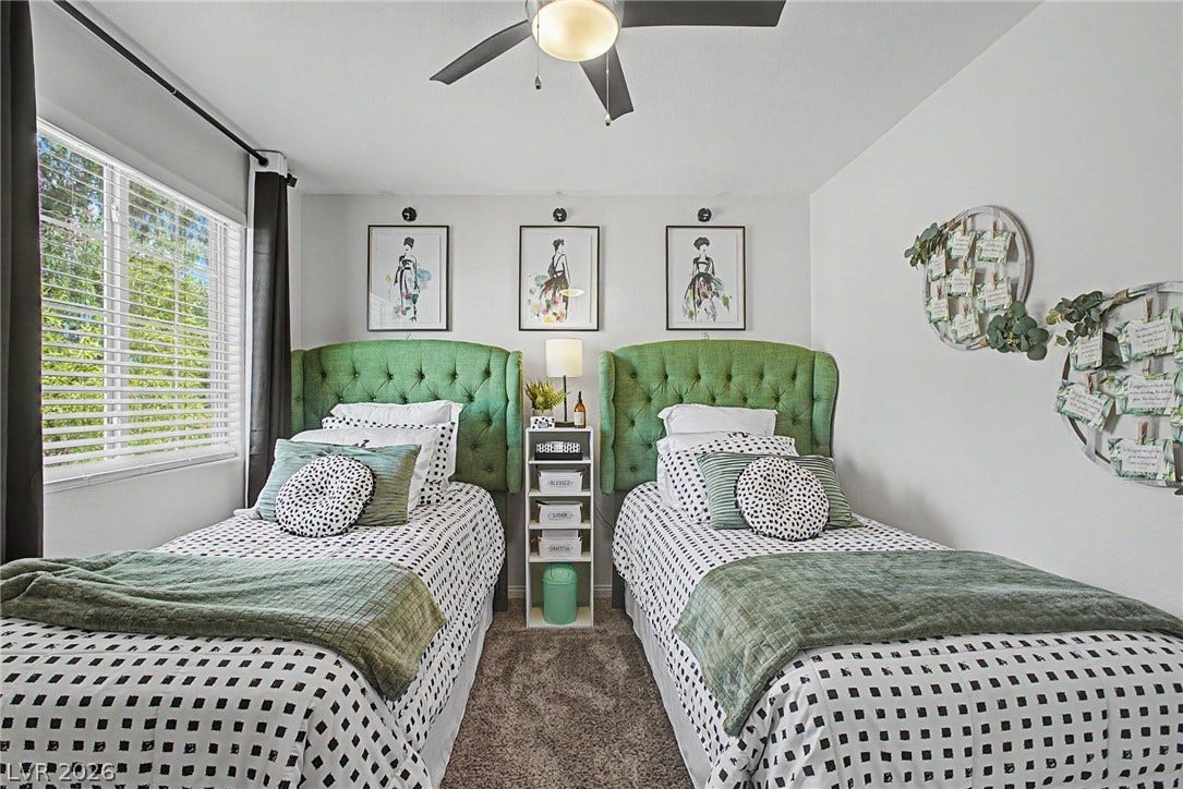 6025 Glenborough Street, North Las Vegas, NV 89115 A spacious bedroom features soft wall-to-wall carpeting and a wide multi-pane window.