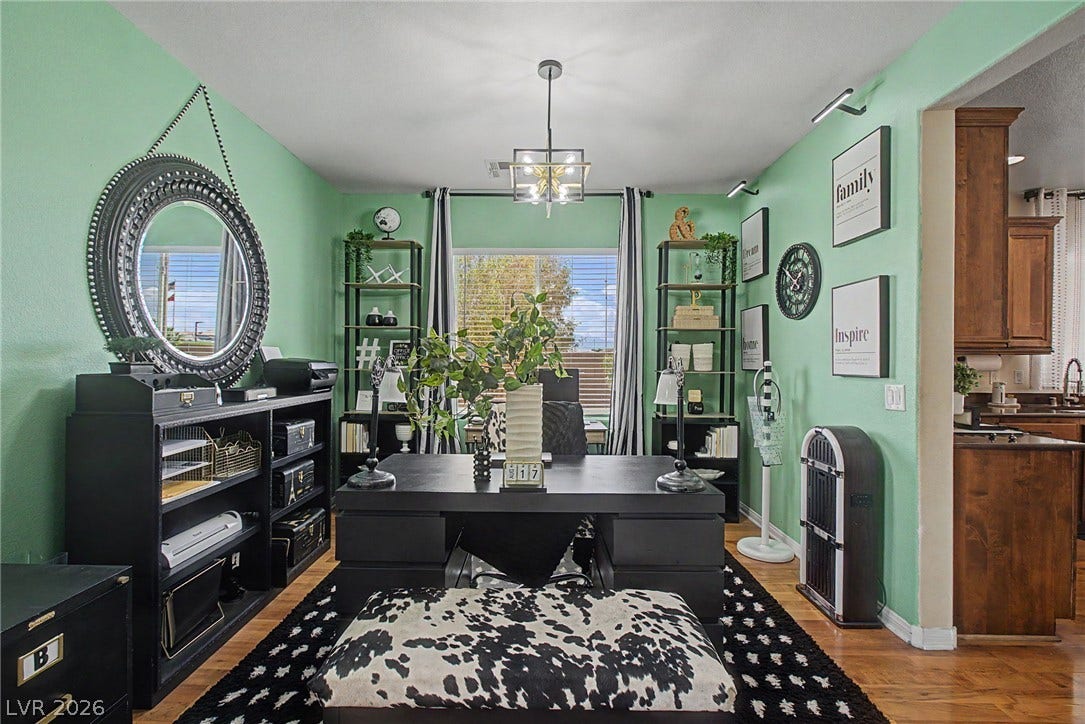 6025 Glenborough Street, North Las Vegas, NV 89115 Hardwood floors and a wide window with blinds elevate this versatile home office space.