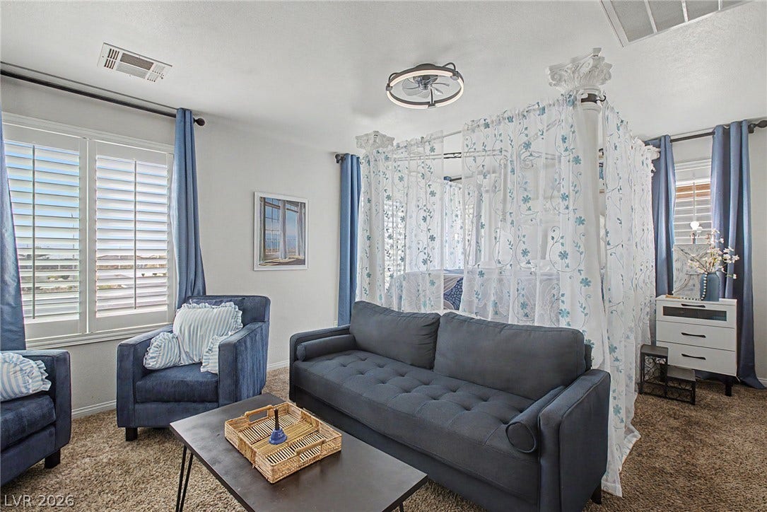 6025 Glenborough Street, North Las Vegas, NV 89115 Plentiful natural light streams across the carpeted floors and clean architectural lines of this bedroom.