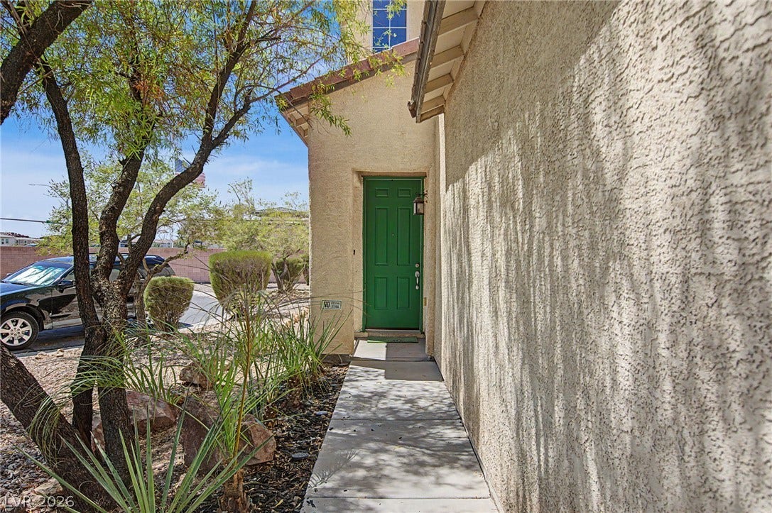 6025 Glenborough Street, North Las Vegas, NV 89115 A concrete walkway leads to the private entrance of this stucco home.
