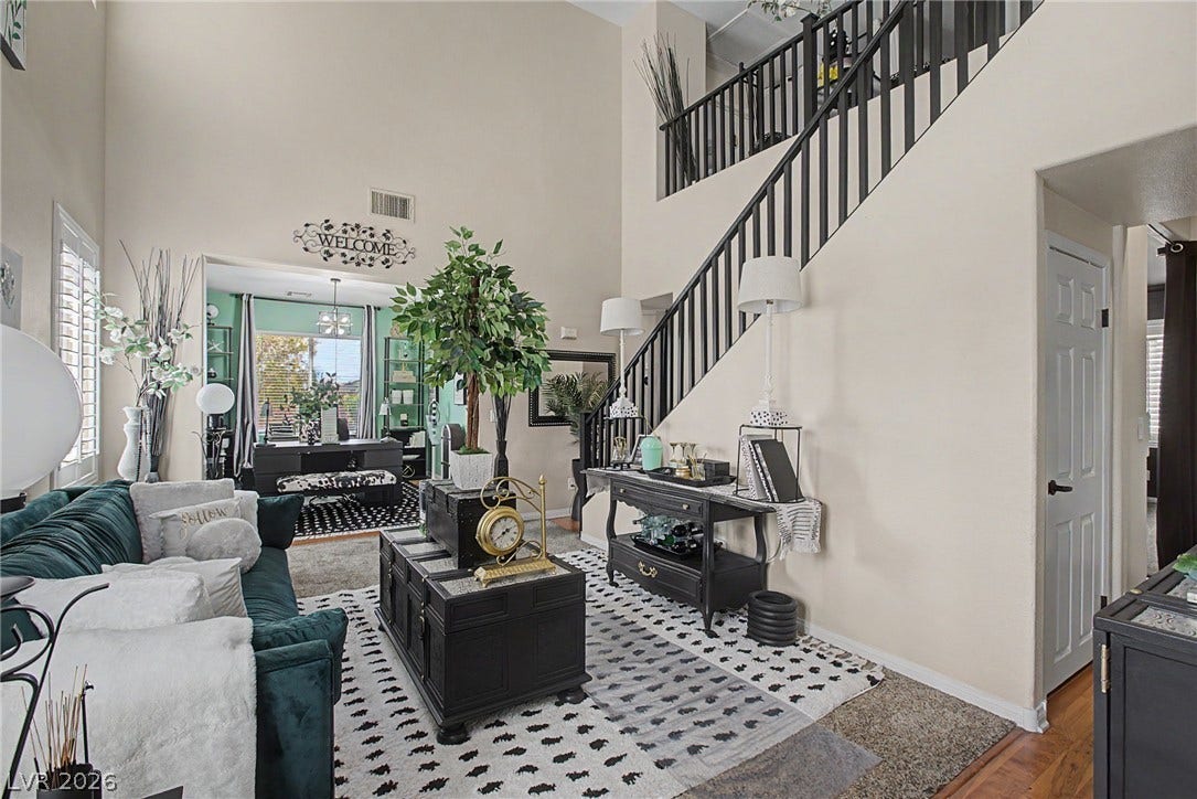 6025 Glenborough Street, North Las Vegas, NV 89115 High ceilings and a prominent staircase define this airy, open-concept living space.