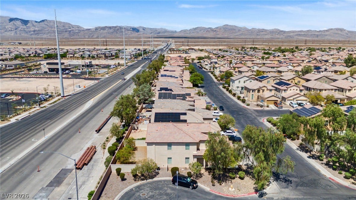 6025 Glenborough Street, North Las Vegas, NV 89115 Distant mountains frame a sprawling desert community showcasing tile roofs and clean residential streets.