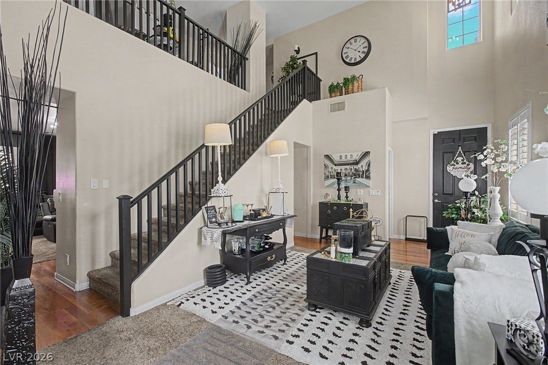 6025 Glenborough Street, North Las Vegas, NV 89115 Dramatic high ceilings and a central staircase anchor this light-filled entry and living space.