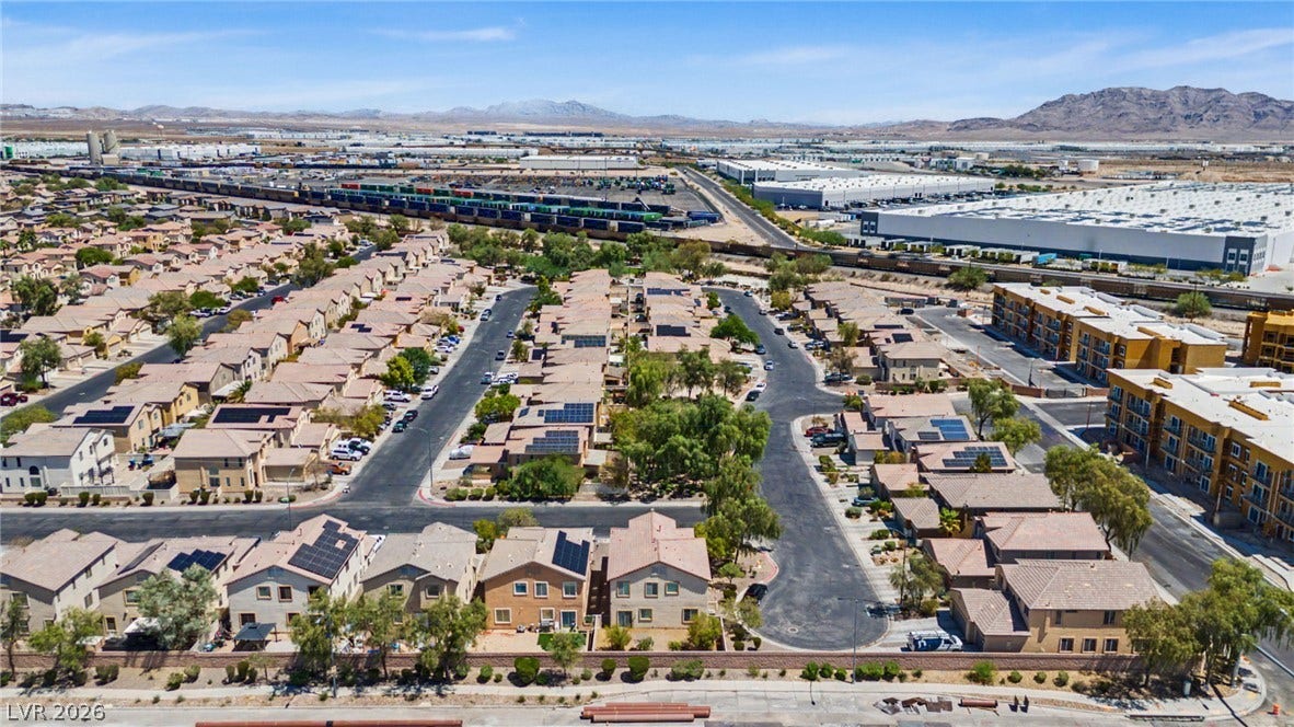 6025 Glenborough Street, North Las Vegas, NV 89115 A sweeping aerial view showcases the surrounding neighborhood nestled against a mountainous backdrop.