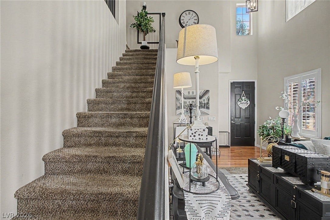 6025 Glenborough Street, North Las Vegas, NV 89115 A soaring ceiling and carpeted staircase create a grand entrance in this open foyer.