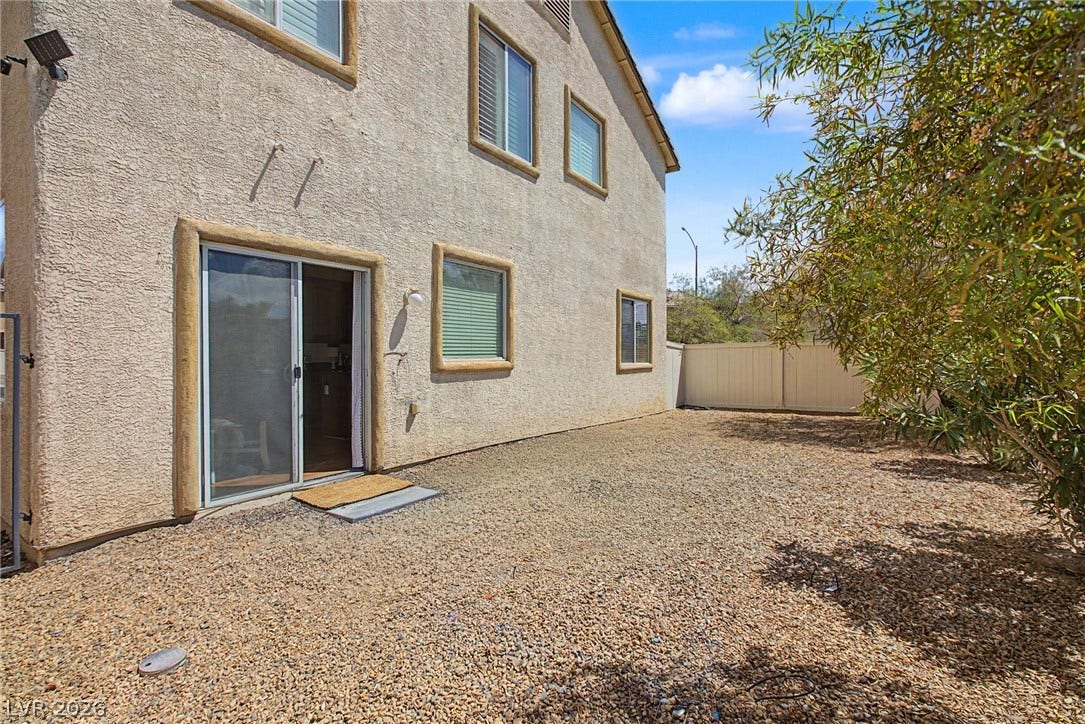 6025 Glenborough Street, North Las Vegas, NV 89115 Sliding doors open from the stucco exterior to a low-maintenance gravel yard.