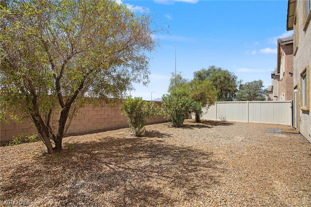 6025 Glenborough Street, North Las Vegas, NV 89115 Mature trees and low-maintenance landscaping define this enclosed outdoor space.
