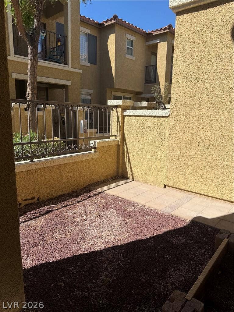 An inviting private courtyard features low-maintenance gravel landscaping, paved walkways, and sturdy stucco walls.