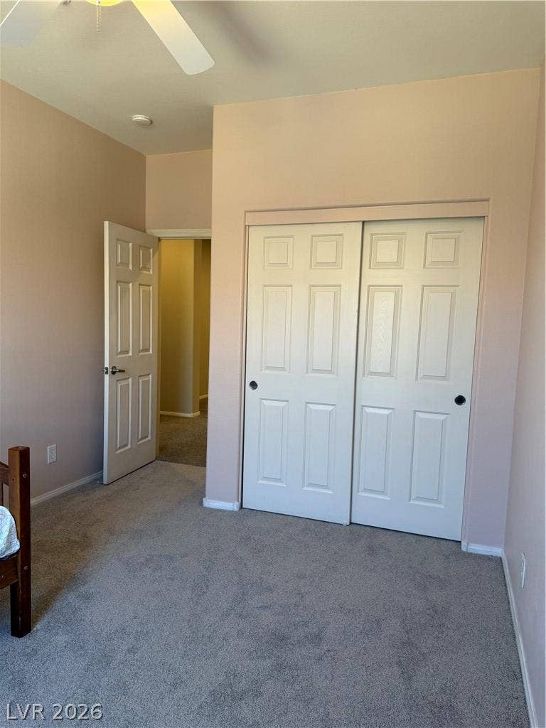 Plush wall-to-wall carpeting and tall ceilings frame this comfortable bedroom space.