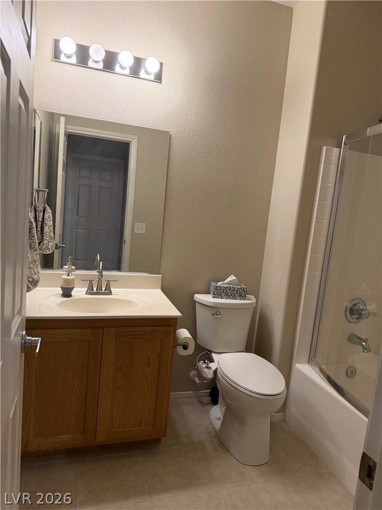 An inviting bathroom pairs a classic wood vanity with tiled tub surround detailing.